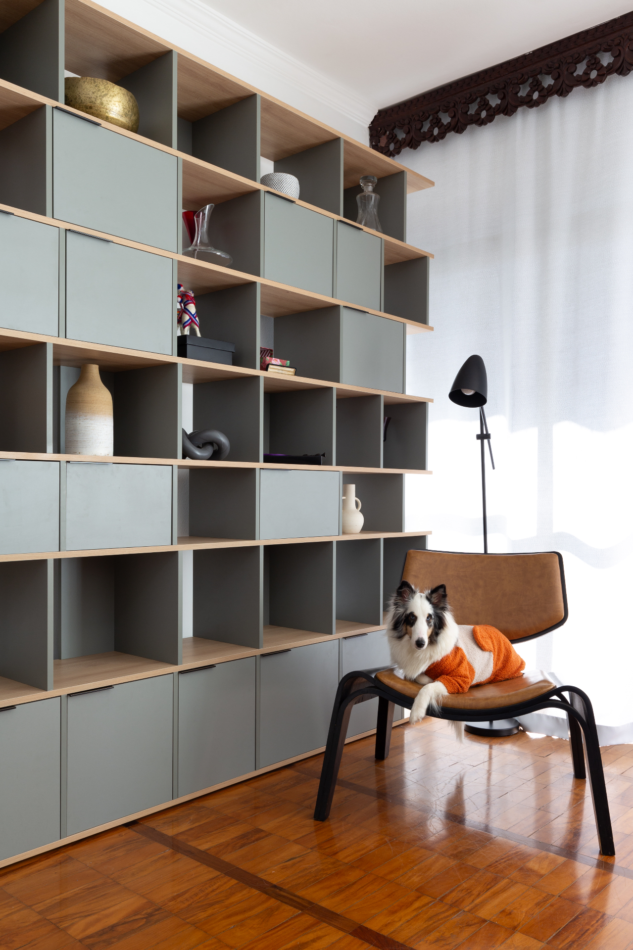 Estante sob medida em sala de estar com cachorro na poltrona